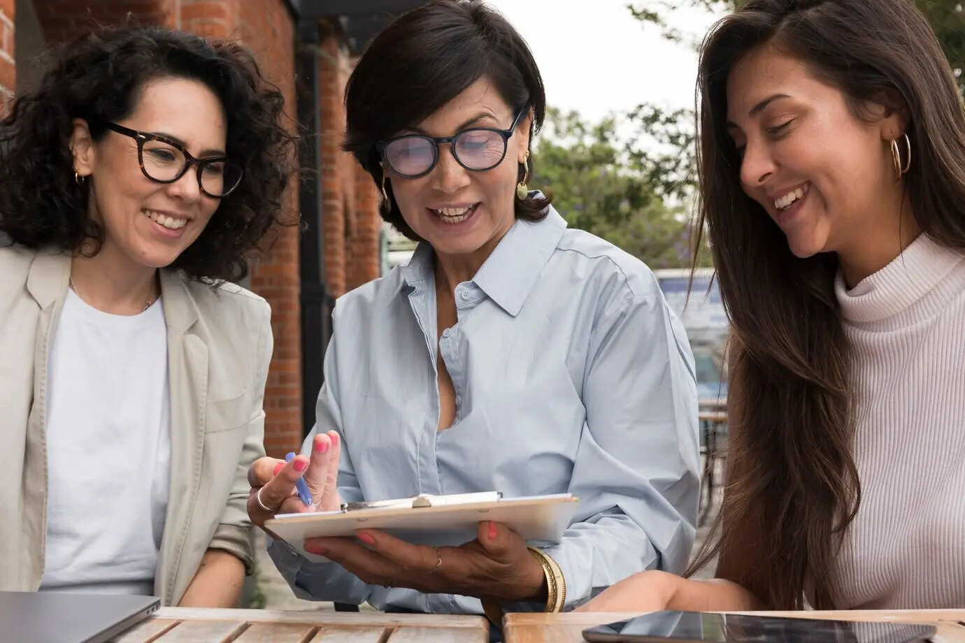 Lächelnde Frauen, die draußen zusammenarbeiten.