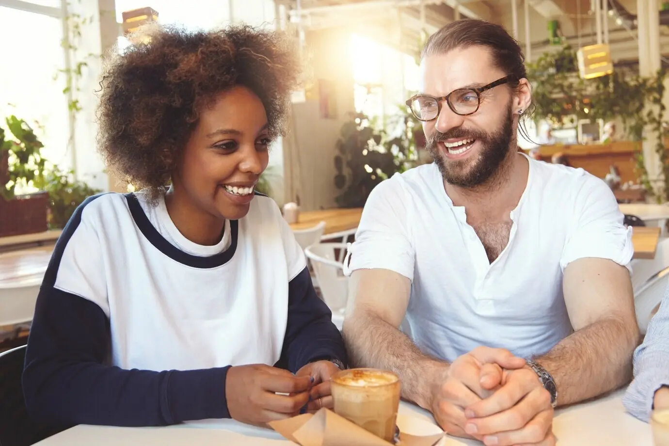 Team junger Kolleginnen und Kollegen bei einem Meeting in einem Café